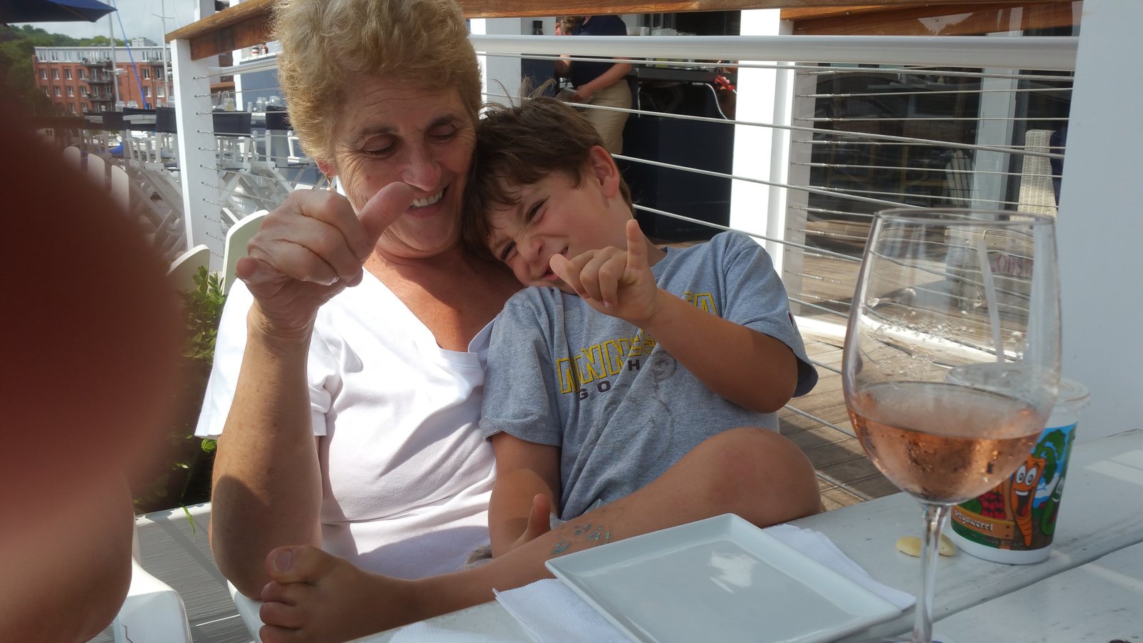 Mum and her grandson laughing at the table, both giving a thumbs up.