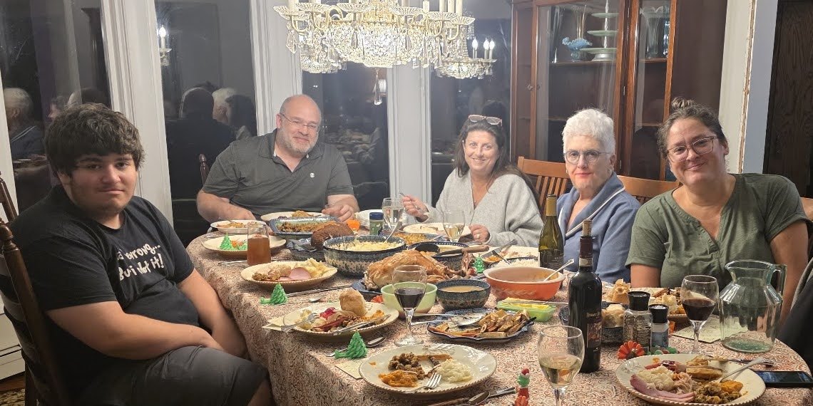 The family around the dining table, the meal in front of them.